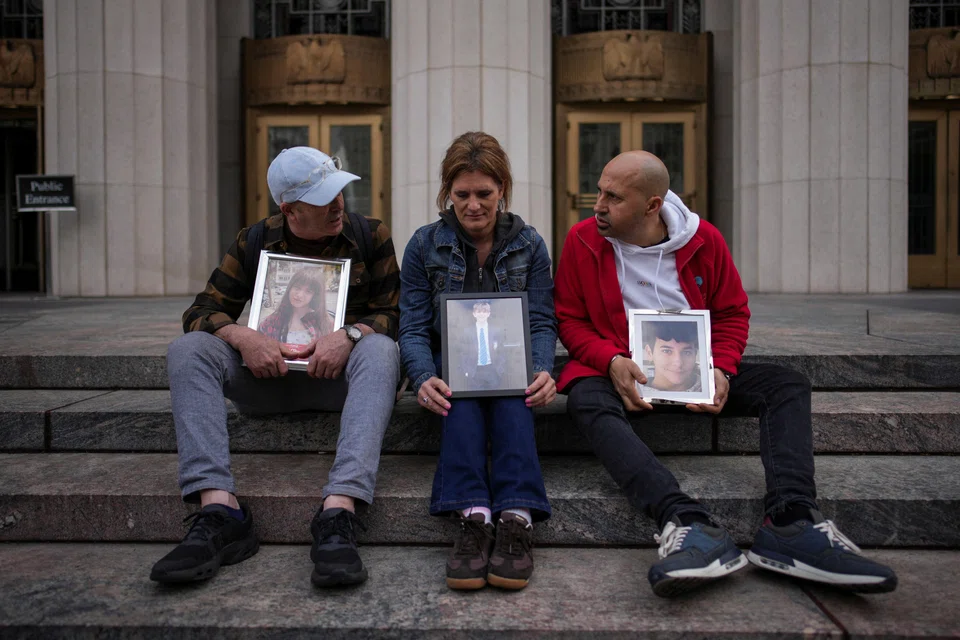 (From left) Mariano Janin, Ellen Roome, and George Nicolaou sit outside a court with photos of their children who died, during a trial in a key test case accusing Meta and Google's YouTube of harming children's mental health through addictive platforms, Los Angeles, California, Feb 11, 2026. 