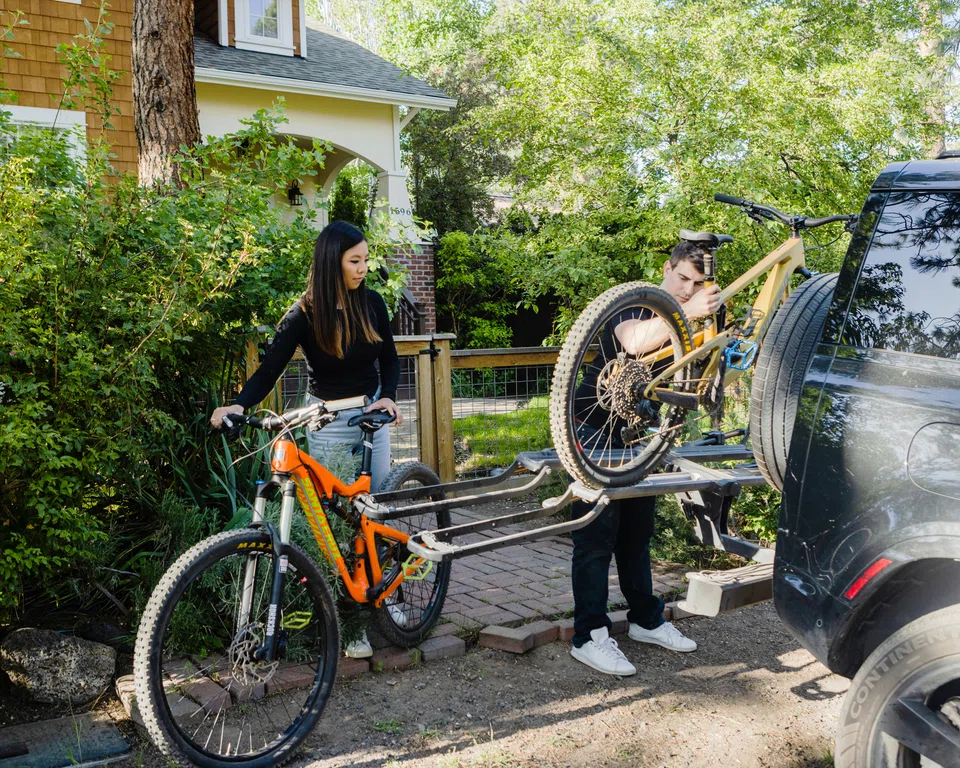 Doug Fulop and Jessie Fischer, who are moving back to the San Francisco Bay Area, load mountain bikes onto their car outside their home in Bend, Ore., May 29, 2023.