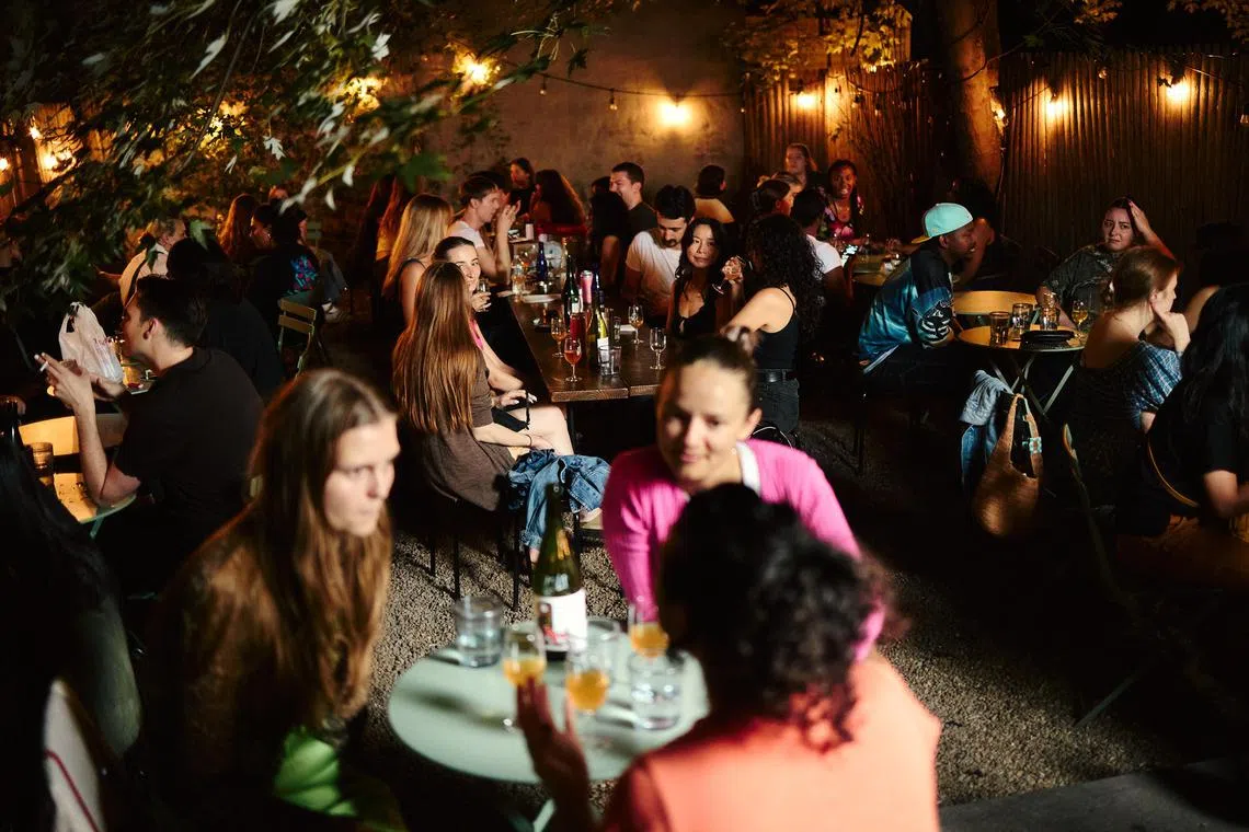 Patrons fill the tables at Frog, a wine bar in Brooklyn where young people come for the casual, unpretentious atmosphere as much as the natural wine, Sept. 14, 2024. Young people may be drinking fewer alcoholic beverages, but natural wine appears to be among their favorite choices. (Marissa Alper/The New York Times)