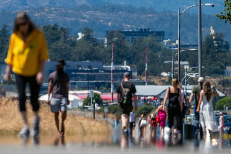 Pedestrians on the oceanside Dallas Road pathway during a heatwave in Victoria, British Columbia, Canada, July 6, 2024. 