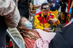 A woman receives medical attention after being rescued from Taroko National Park, following an earthquake, in Hualien, Taiwan.