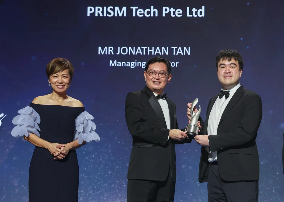 Jonathan Tan, founder and managing director of Prism Tech (right) receiving his trophy from DPM Heng. Accompanying them is Lee Sze Yeng, managing
partner, KPMG in Singapore (left).