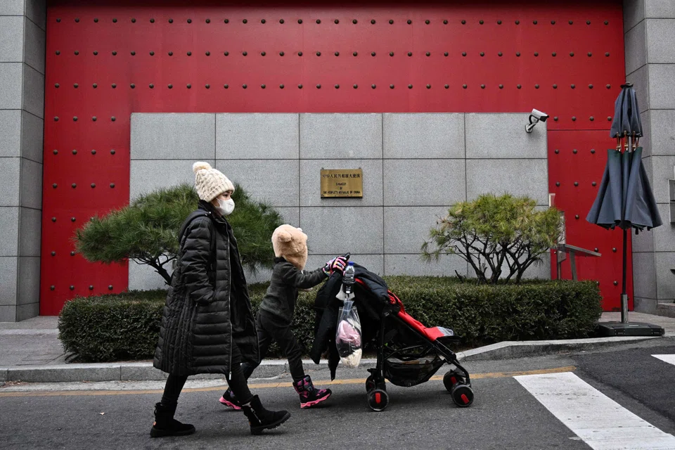 Pedestrians outside the Chinese embassy in Seoul on Jan 10, 2023 - China has suspended the issuing of short-term visas to South Koreans in response to Seoul's imposition of travel curbs on Chinese travellers over Covid concerns.