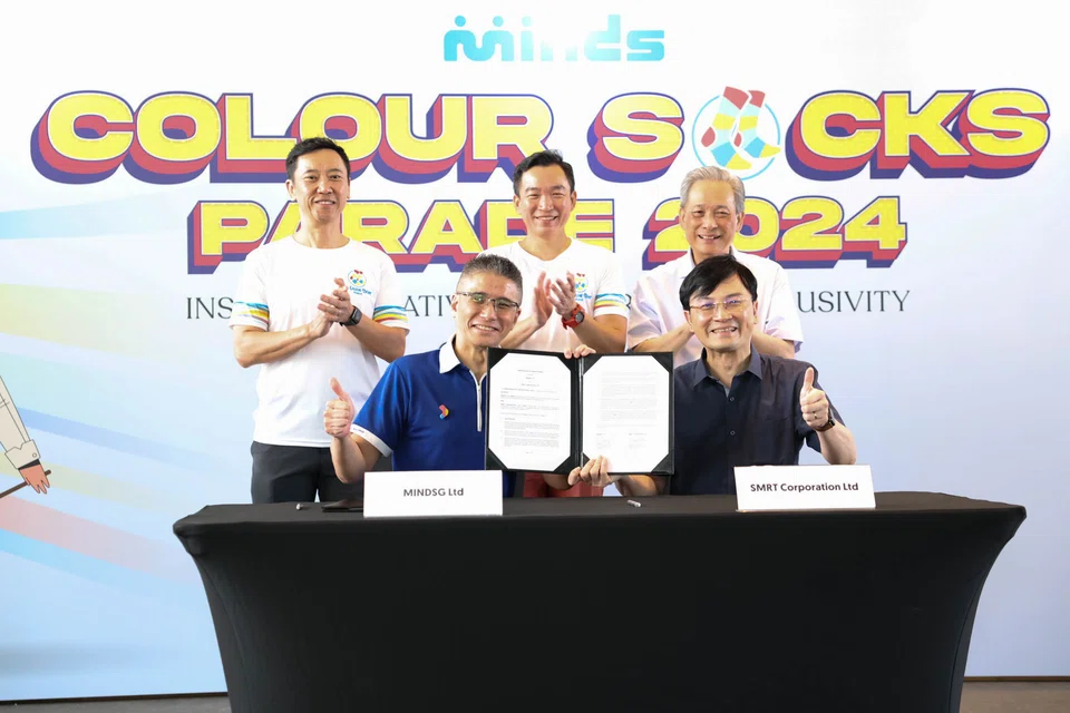 Senior Parliamentary Secretary Eric Chua (back row, centre), Minds chief executive Kelvin Koh (front row, left) and SMRT group chief executive Ngien Hoon Ping (front row, right) at the signing of the MOU at the Inclusive Arts Festival.