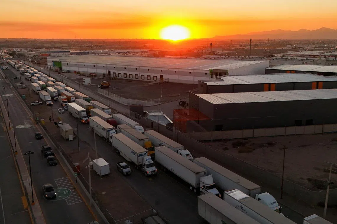 Trucks waiting to cross into the US from Mexico. President Trump's tariffs on goods from Mexico, Canada and China  will raise the cost of key goods, such as food, housing, and petrol for Americans.