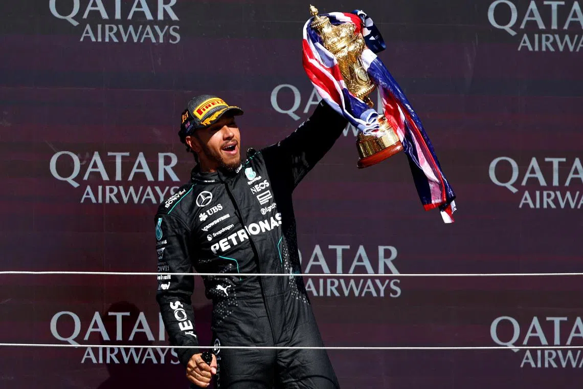 Mercedes driver Lewis Hamilton celebrating with his trophy on the podium after winning the British Grand Prix at Silverstone in July. 
