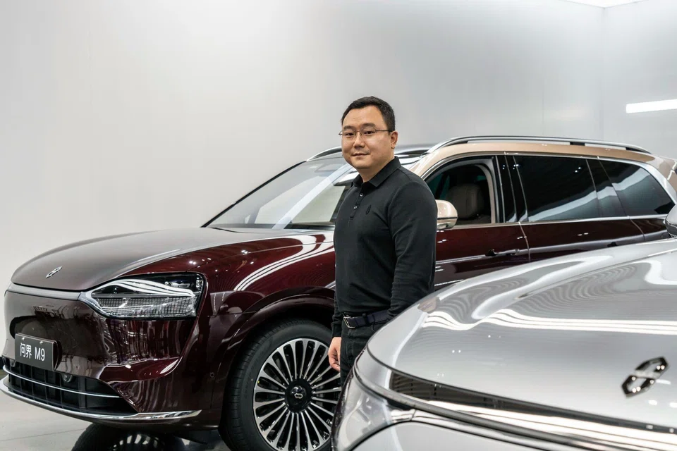 Zhang Zhengping, chairman and president of Seres Group Co., with an Aito M9 SUV at the company's Super Factory in Chongqing on Oct 20. 