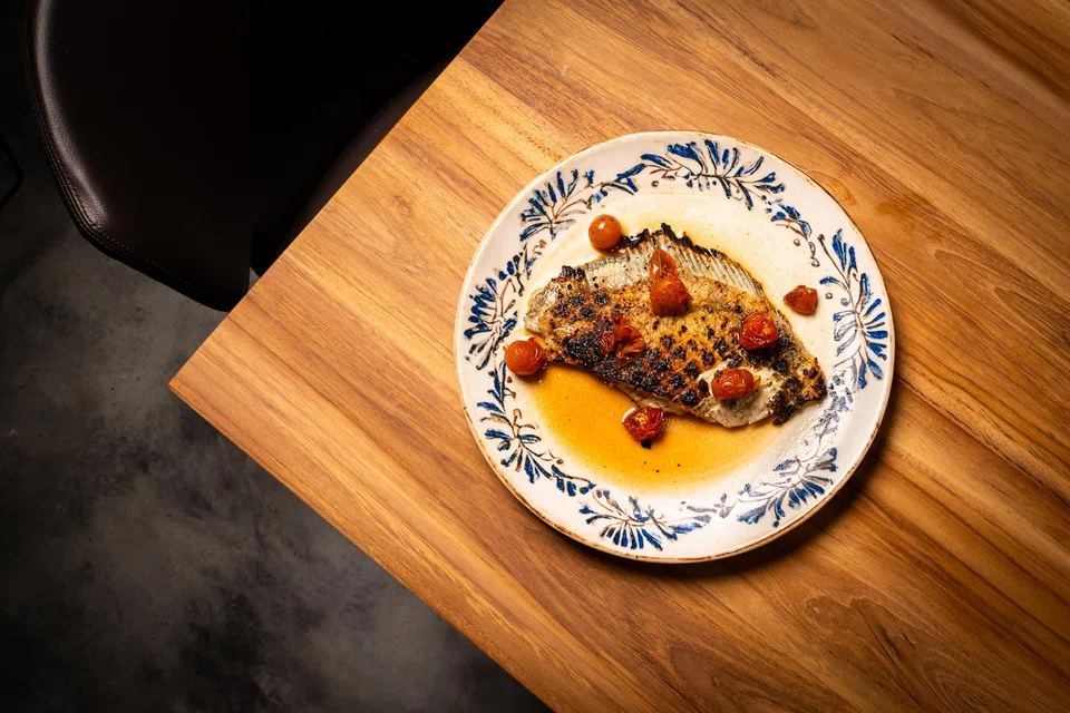 The grilled turbot in smoked dashi with tomatoes.