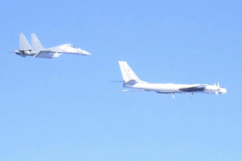 This photo from Japan's Ministry of Defense shows a Chinese J-16 fighter jet (L) and a Russian Tu-95 bomber during a joint flight over the sea near Japan. 