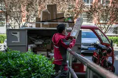 A worker sorts packages on a JD.com delivery truck in Beijing, China, April 28, 2025. China's new turf war focused on speed is coming at a high cost in the short term as e-commerce giants look to entice consumers with hefty discounts.