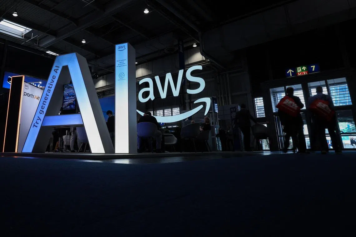 Visitors walk past the letters AI for Artificial Intelligence at the booth of Amazon Web Services (AWS) during the opening of the Hannover Messe industrial trade fair for mechanical and electrical engineering and digital industries, on March 31, 2025 in Hanover, northern Germany. The fair opens its doors to the public on March 31 and will be running until April 4, 2025. According to the Hannover Messe, "more than 4,000 companies will be acting as an interconnected industrial ecosystem and demonstrating how climate neutrality can be achieved through electrification, digitization and automation". (Photo by RONNY HARTMANN / AFP)