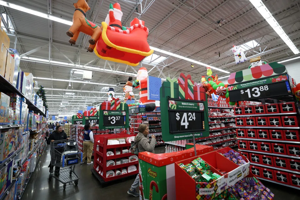 Customers walk through holiday shopping displays at a Walmart retail store in North Bergen, New Jersey, Nov 21, 2025.  