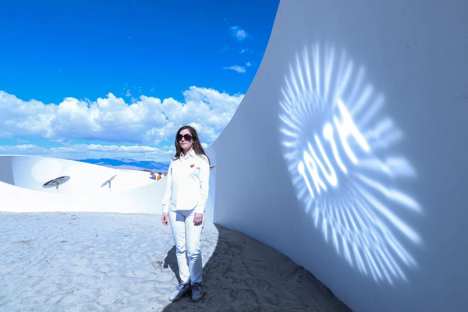 French-American artist Sarah Meyohas uses intricately curved metallic mirrors to reflect and refract the bright desert sunlight, beaming the words “Truth Arrives in Slanted Beams” across the sides of a meandering 120m stucco ribbon.