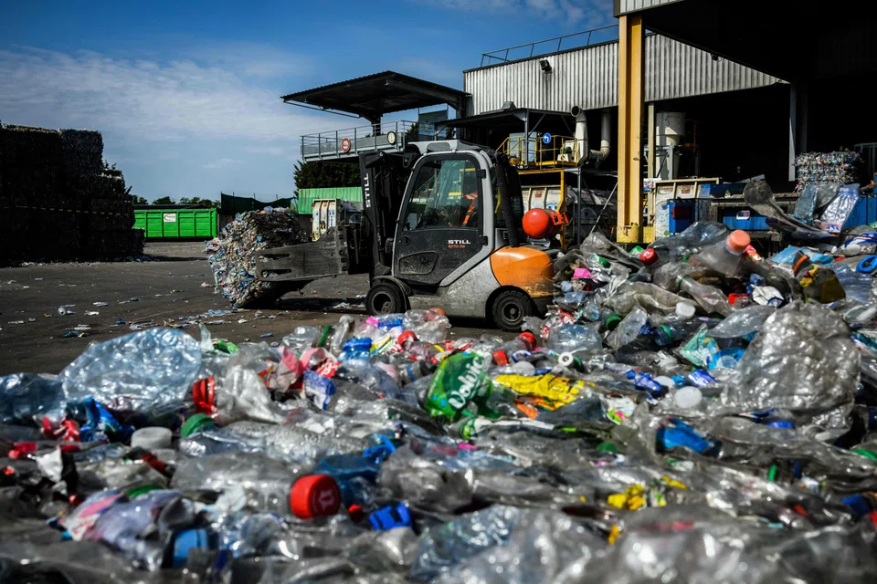 A forklift moves bales of PET plastic bottles before they are recycled at the Plastipak Infineo recycling plant in Saint-Marie-La-Blanche, France, June 1, 2023. In 2019, the world produced around 460 million tonnes of plastic, a figure that has doubled since 2000, according to OECD.