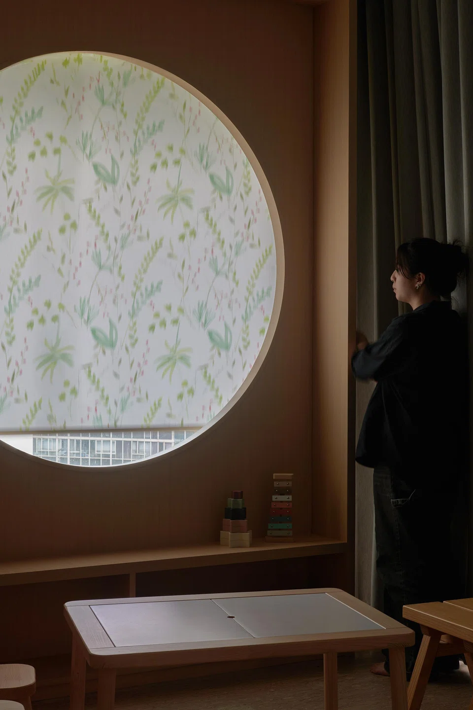 A round window in the playroom cabinetry.