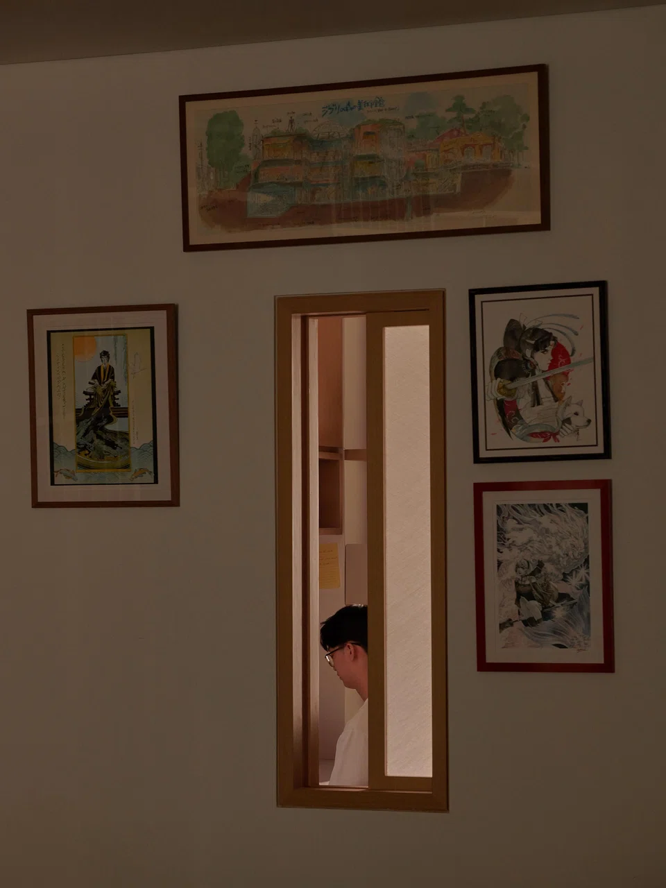 An internal window between the living room and Teo's study is surrounded by art.