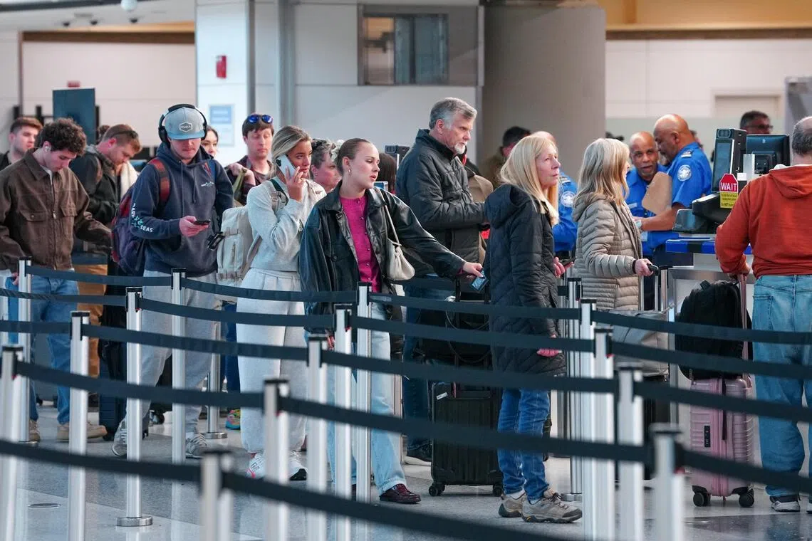 Passengers walk through a queue to enter a TSA security checkpoint at Ronald Reagan International Airport in Arlington, Virginia., March 15, 2026. 