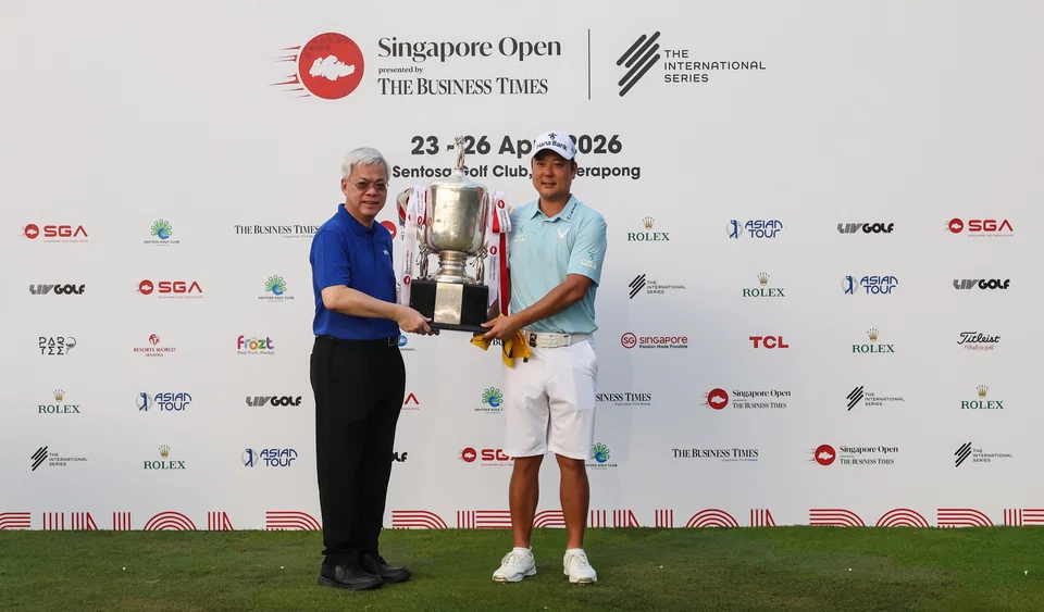 Ham Jeong-woo (right) receiving his Singapore Open trophy from SPH Media CEO Chan Yeng Kit at the Sentosa Golf Club on Sunday. 