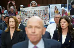 A placard with photos of those killed on Ethiopian Airlines Flight 302 is held up as Boeing's CEO Dave Calhoun testifies before a Senate Homeland Security and Governmental Affairs Committee Investigations Subcommittee hearing on the safety culture at Boeing, on Capitol Hill in Washington, US, June 18, 2024. 