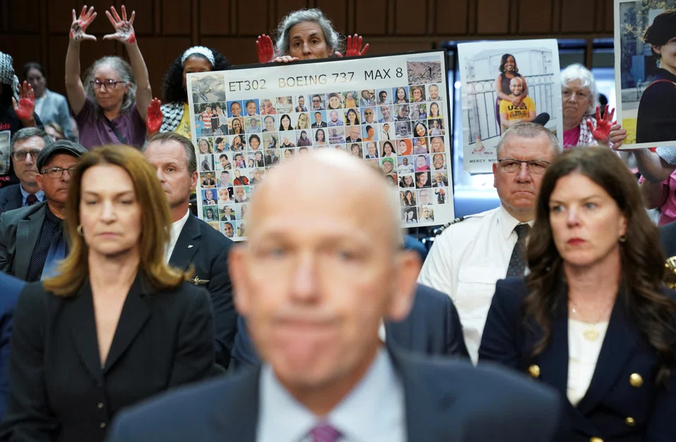 A placard with photos of those killed on Ethiopian Airlines Flight 302 is held up as Boeing's CEO Dave Calhoun testifies before a Senate Homeland Security and Governmental Affairs Committee Investigations Subcommittee hearing on the safety culture at Boeing, on Capitol Hill in Washington, US, June 18, 2024. 