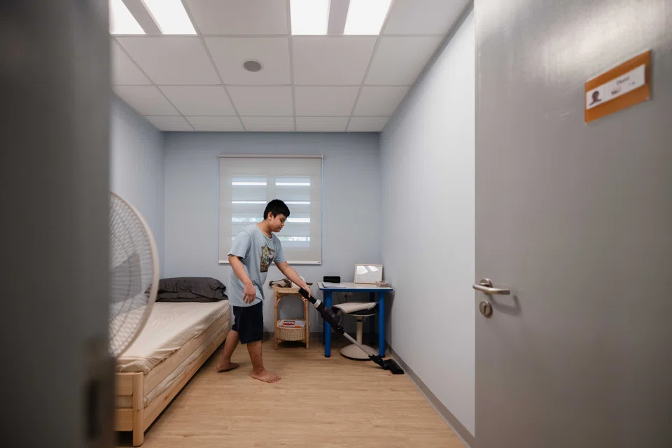 Student Hirdani Adrean bin Abdul Halim, 14, vacuuming his room at Good Life Boarding, an apartment-style living lab where he learns independent living skills and household tasks under the guidance of life coaches.
