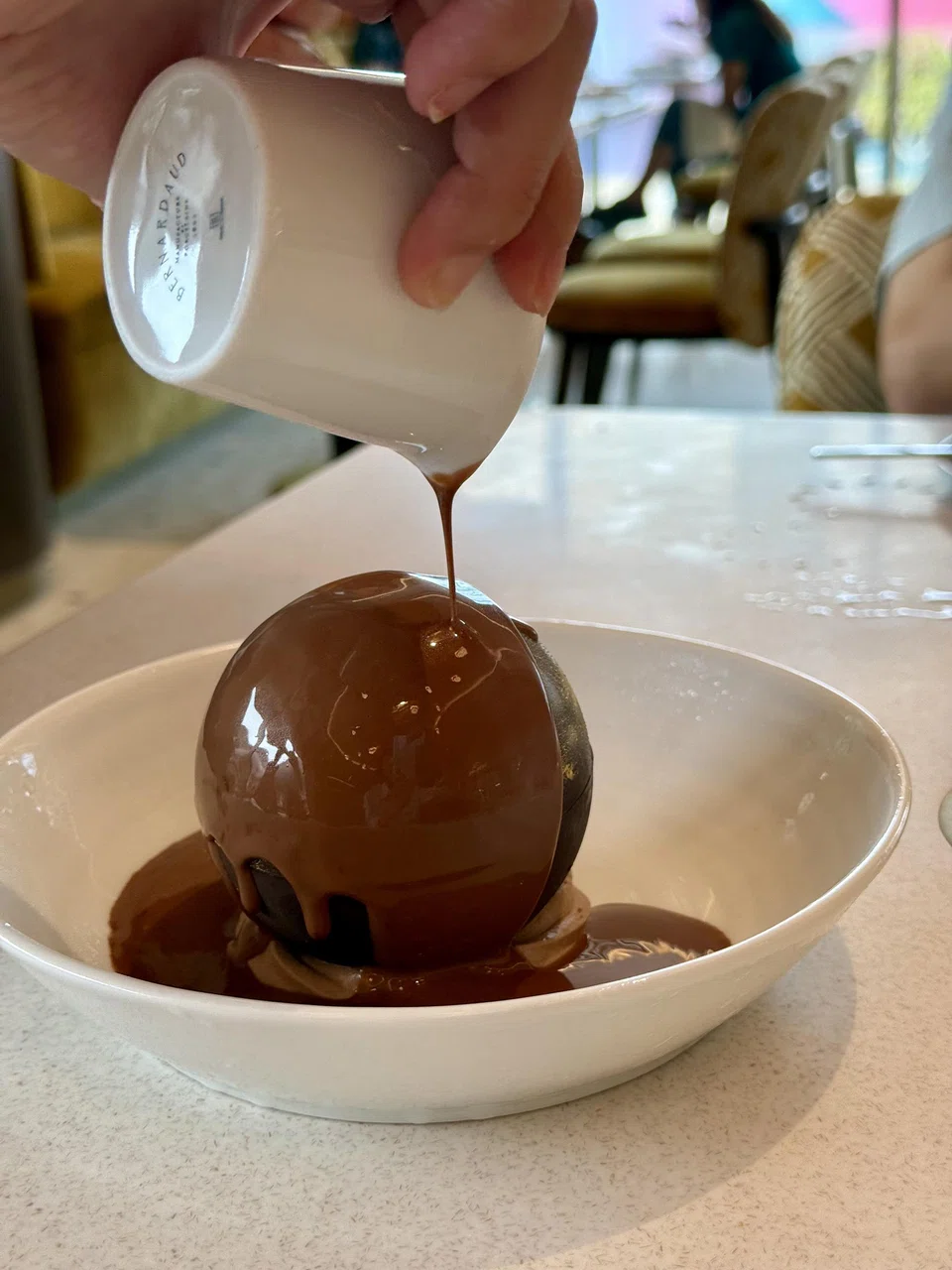 Sensation Orpheo, a filled chocolate sphere dessert.