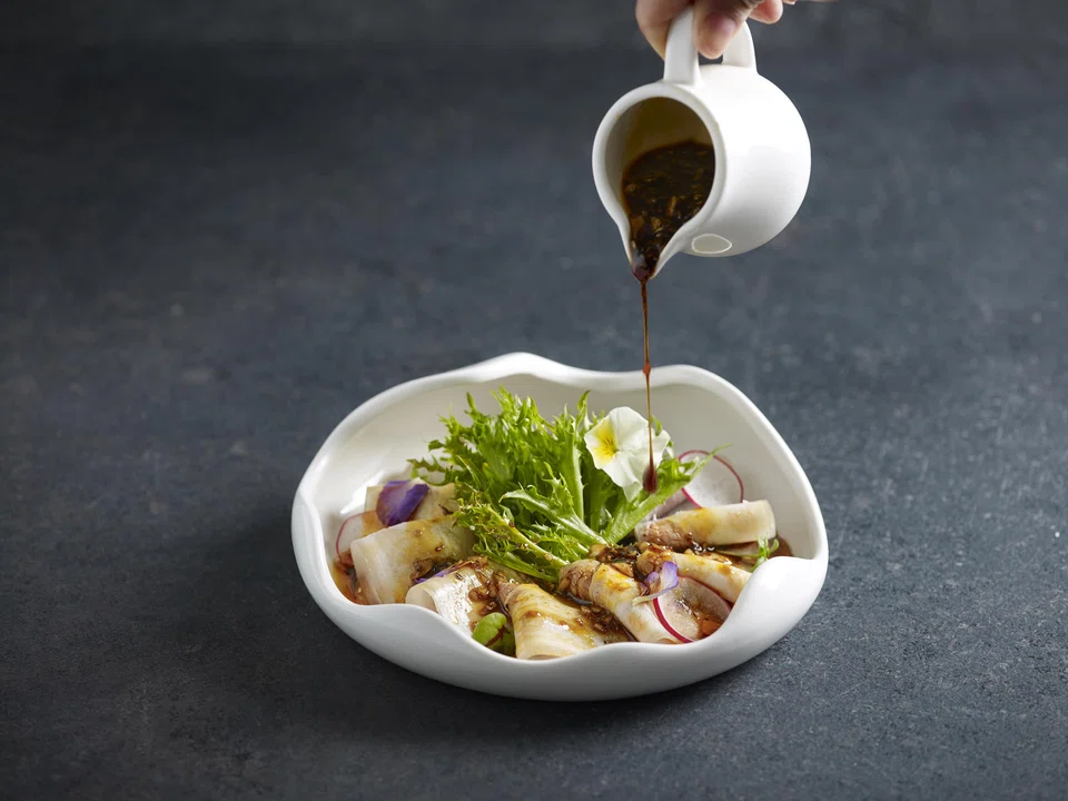 Slices of cold pork belly and cucumbers are doused in a tasty spicy sauce.