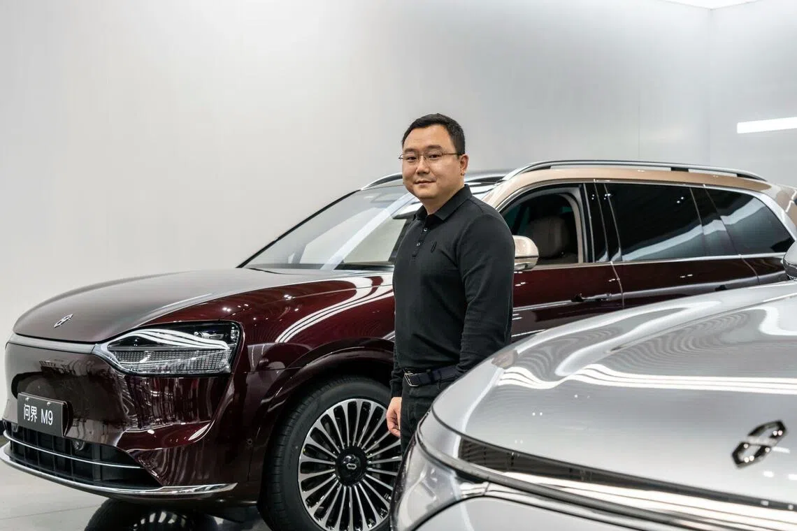Zhang Zhengping, chairman and president of Seres Group Co., with an Aito M9 SUV at the company's Super Factory in Chongqing on Oct 20. 
