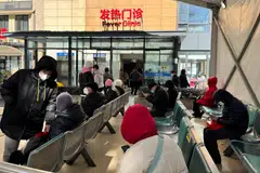 People wait outside a fever clinic at a hospital in Shanghai. A wave of Covid infections has spread across the country in recent weeks, disrupting factory production as workers fall ill.