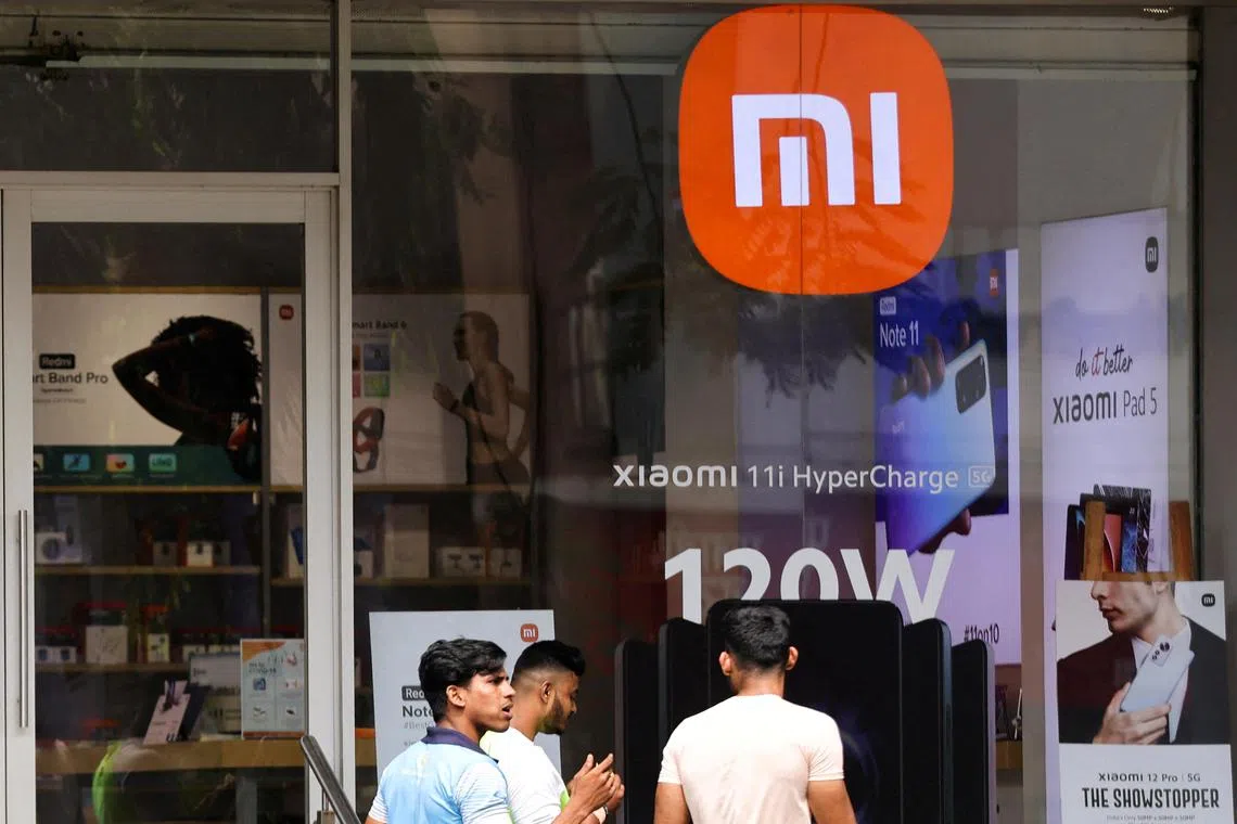 FILE PHOTO: People walk past Xiaomi, a Chinese manufacturer of consumer electronics, store in Mumbai, India, May 11, 2022. REUTERS/Francis Mascarenhas/File Photo