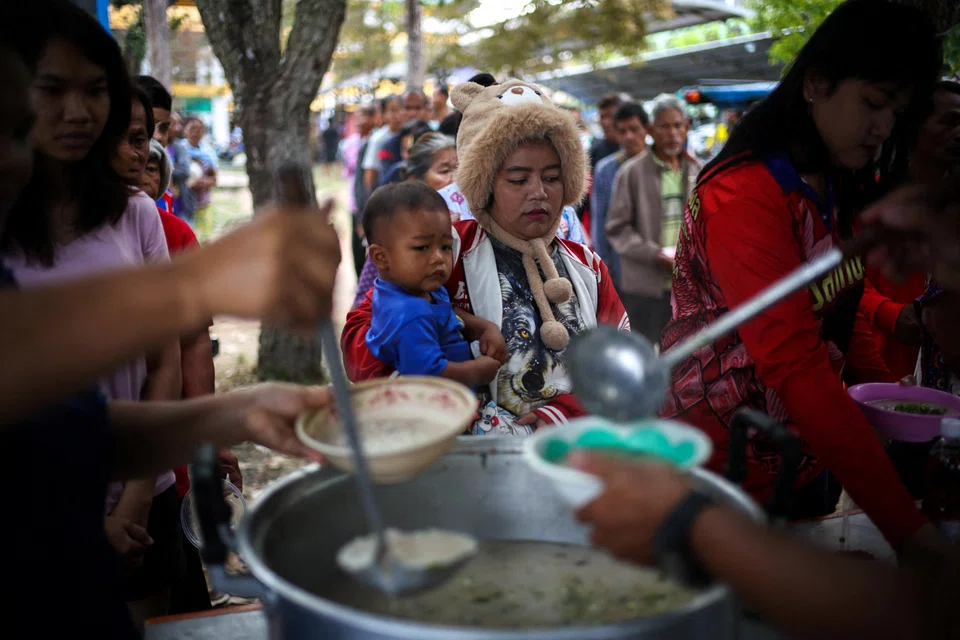 Displaced people queue for food at a school turned temporary shelter, amid clashes between Thailand and Cambodia along a disputed border area in Surin province, Thailand.