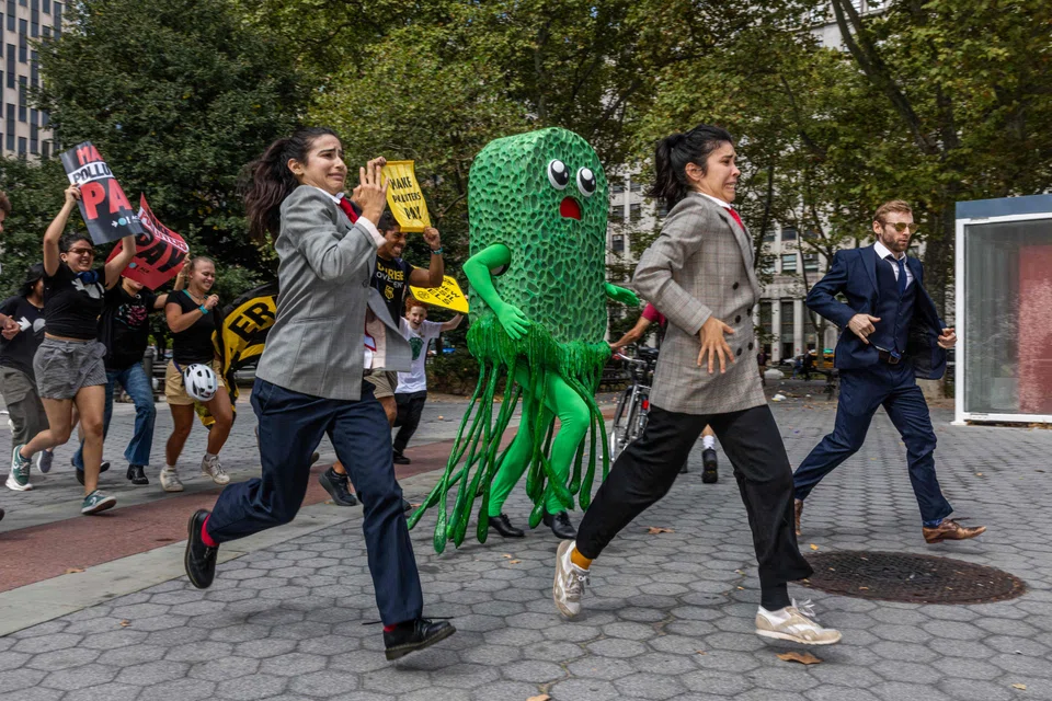 A "greenwashing" character chasing activists during a climate demonstration in New York City. There is now greater enforcement over greenwashing claims, with stricter penalties and more detailed reporting requirements becoming the norm.