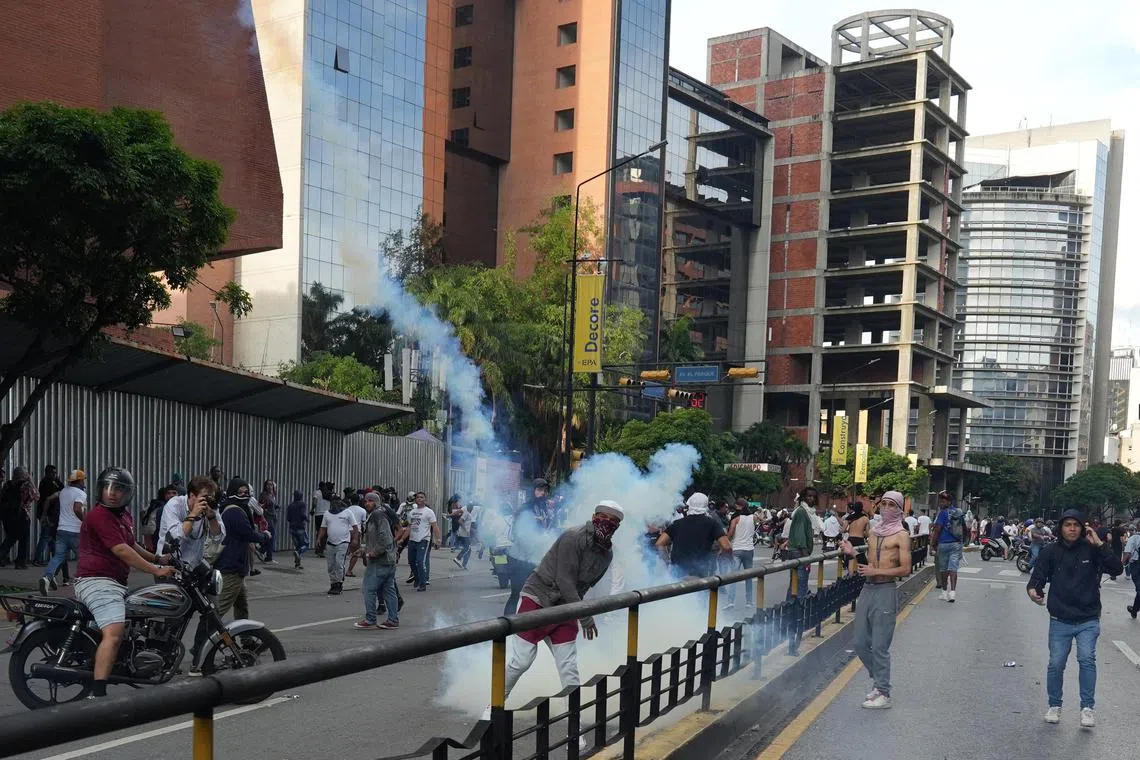 A protester throws back a tear gas canister as Venezuelan opposition supporters protest following the announcement by the National Electoral Council that Venezuela's President Nicolas Maduro won the presidential election, Caracas, Venezuela ,July 29, 2024. 