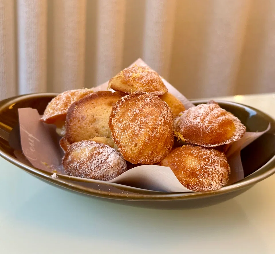 Baby madeleines dusted with powdered sugar.
