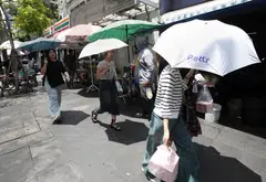 Pedestrians protect themselves from sunlight during a heatwave in Bangkok, Thailand, April 28, 2025.  