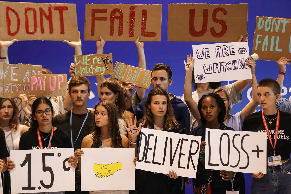 Youth activists hold signs during a demonstration urging world leaders to maintain policies that limit warming to 1.5 degrees Celsius since pre-industrial times and provide reparations for loss and damage, at COP27, in Sharm el-Sheikh, Egypt, Nov 19, 2022.