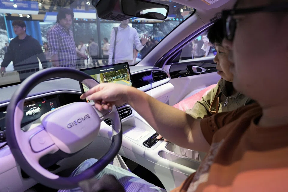 Visitors check the interior of the Geely EX2 at the Beijing Auto Show in Beijing, China, April 26, 2026. 