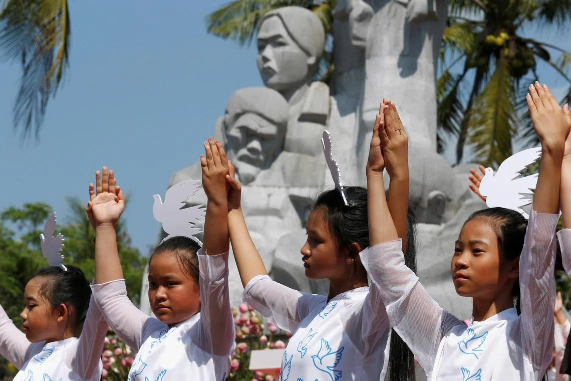 Schoolgirls perform during the 50th anniversary of the massacre in My Lai village, Vietnam, March 16, 2018. 