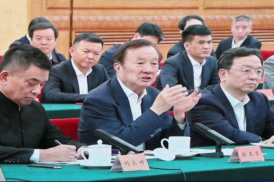 A giant screen shows news footage of Huawei founder Ren Zhengfei speaking next to BYD CEO Wang Chuanfu and New Hope's founder and Chairman Liu Yonghao at a symposium on private enterprises with Chinese President Xi Jinping (not pictured), at a shopping complex in Beijing on Feb 17.