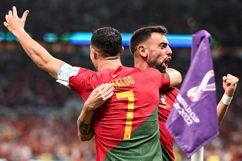 Portugal's forward Cristiano Ronaldo (left) celebrates scoring his team's first goal with Portugal's midfielder Bruno Fernandes during their World Cup match against Uruguay at the Lusail Stadium on Nov 28.