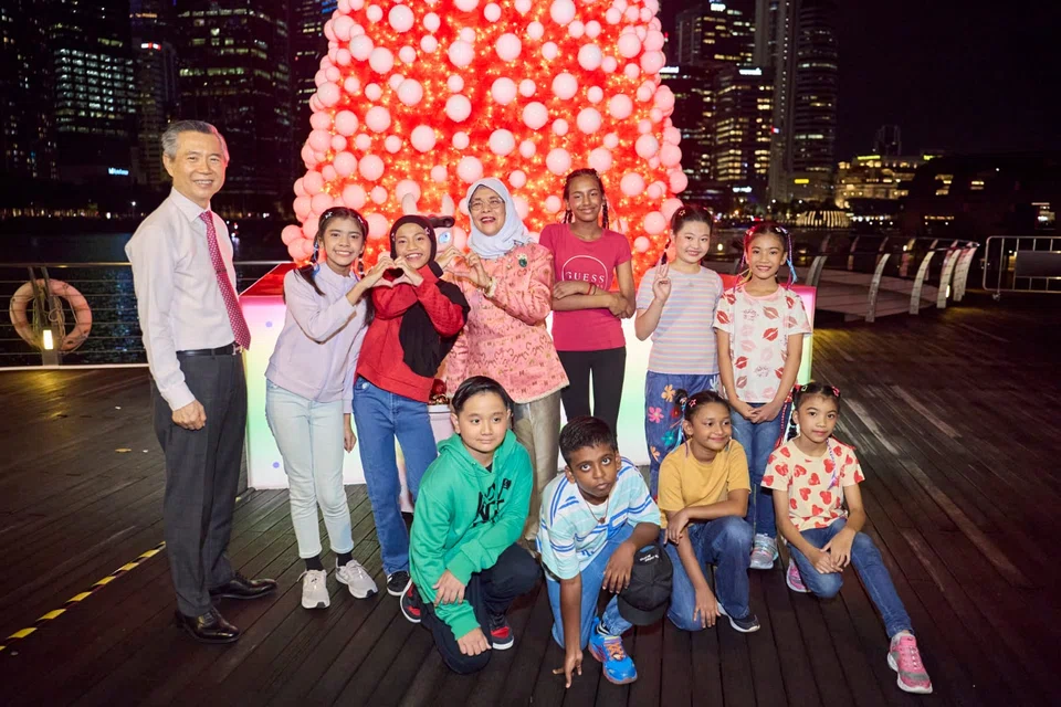 Tan Puay Kern (standing, left), chairman of the ChariTrees 2025 organising committee, and former Singapore president Halimah Yacob (standing, fourth from left) with youth at the launch of the event. 