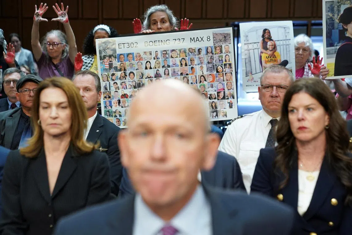 A placard with photos of those killed on Ethiopian Airlines Flight 302 is held up as Boeing's CEO Dave Calhoun testifies before a Senate Homeland Security and Governmental Affairs Committee Investigations Subcommittee hearing on the safety culture at Boeing, on Capitol Hill in Washington, US, June 18, 2024. 