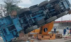 A lorry crane is seen toppled on its left side at an ExxonMobil project site.