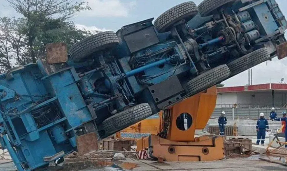 A lorry crane is seen toppled on its left side at an ExxonMobil project site.