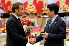 France's Emmanuel Macron shaking hands with his Vietnamese counterpart Luong Cuong. Macron's trip is the first visit by a French president to Vietnam in about a decade.