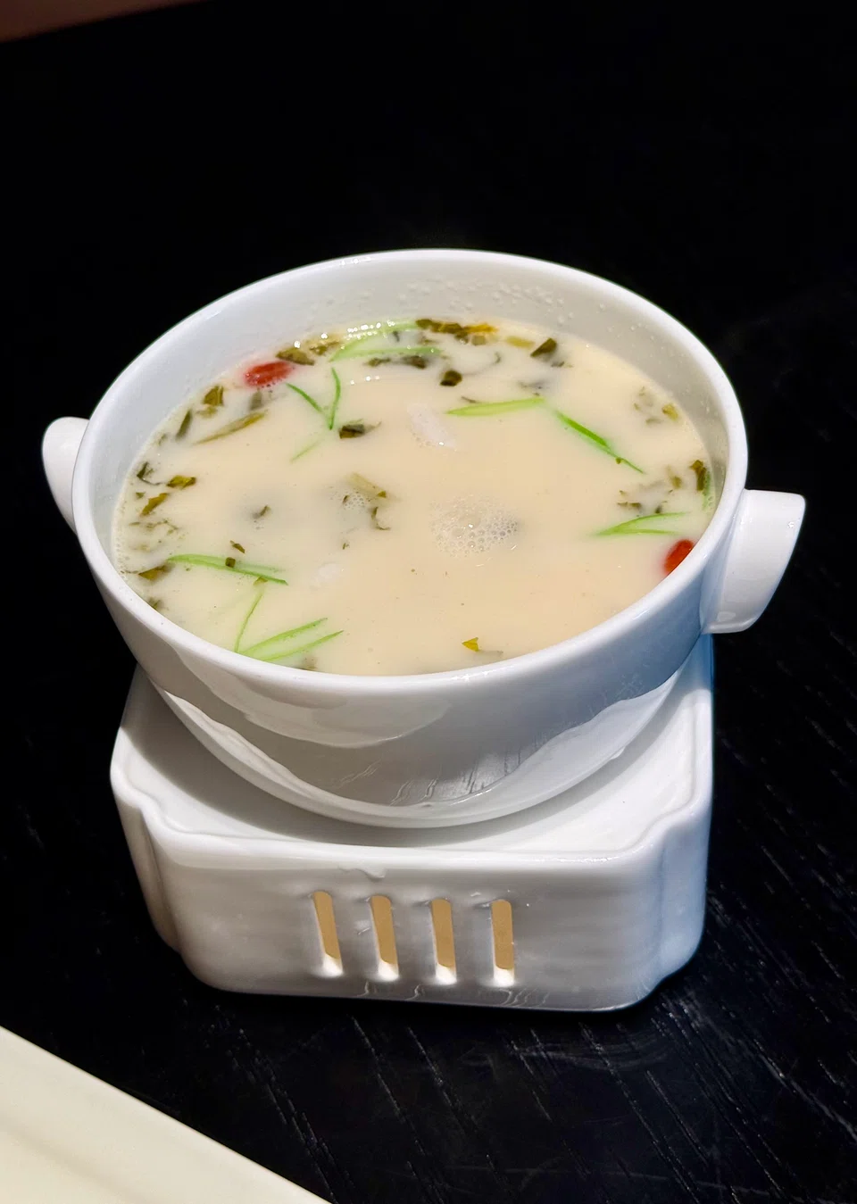 Tangy and milky coral grouper soup with pickled greens and bamboo shoots.