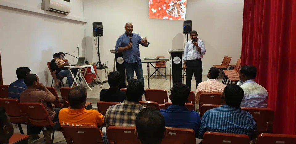Philip Ebeneyer (in dark blue shirt), chairman of non-profit organisation Life Centre Community Services (LCCS), speaks to a group of migrant workers about workplace safety at Tuas Vista.  