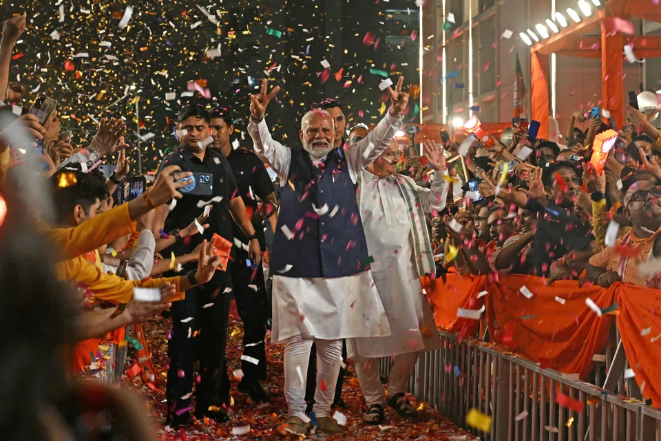 India’s Prime Minister Narendra Modi (C) flashes a victory sign as he arrives at the BJP headquarters to celebrate the party’s win in New Delhi. Modi’s BJP won 240 seats on its own, a weakened verdict which could slow India’s fiscal tightening, ratings agency Moody’s warned.