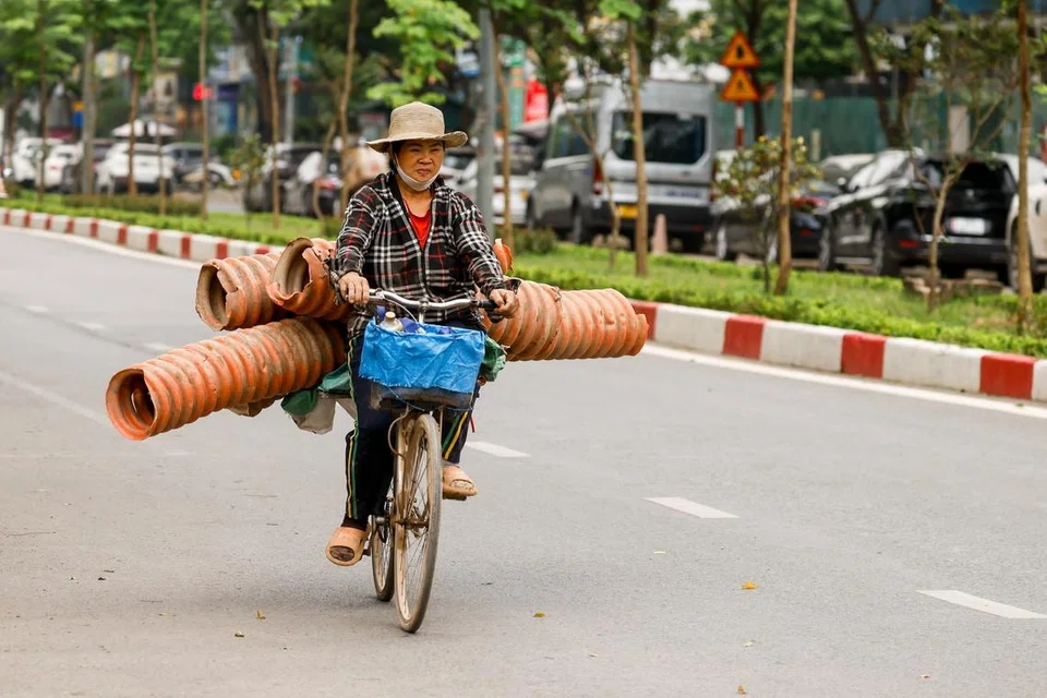 A woman rides bicycle along a street in Hanoi on Apr 16. The country is home to the world’s sixth-largest reserves of rare earths. 