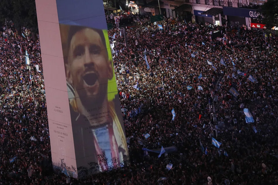 Argentina fans celebrate winning the Fifa World Cup at the Obelisk in Buenos Aires with an image of team captain Lionel Messi.